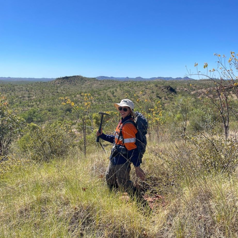 Lluka holding a rock hammer while on exploration fieldwork in the Kimberley 